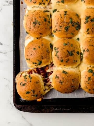 overhead view of BBQ chicken sliders on parchment lined sheet pan