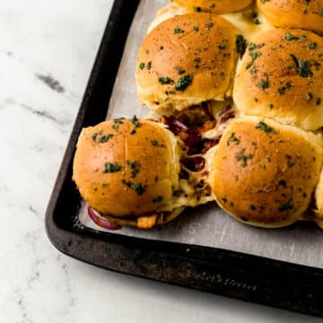 close up side view of finished sliders on sheet pan