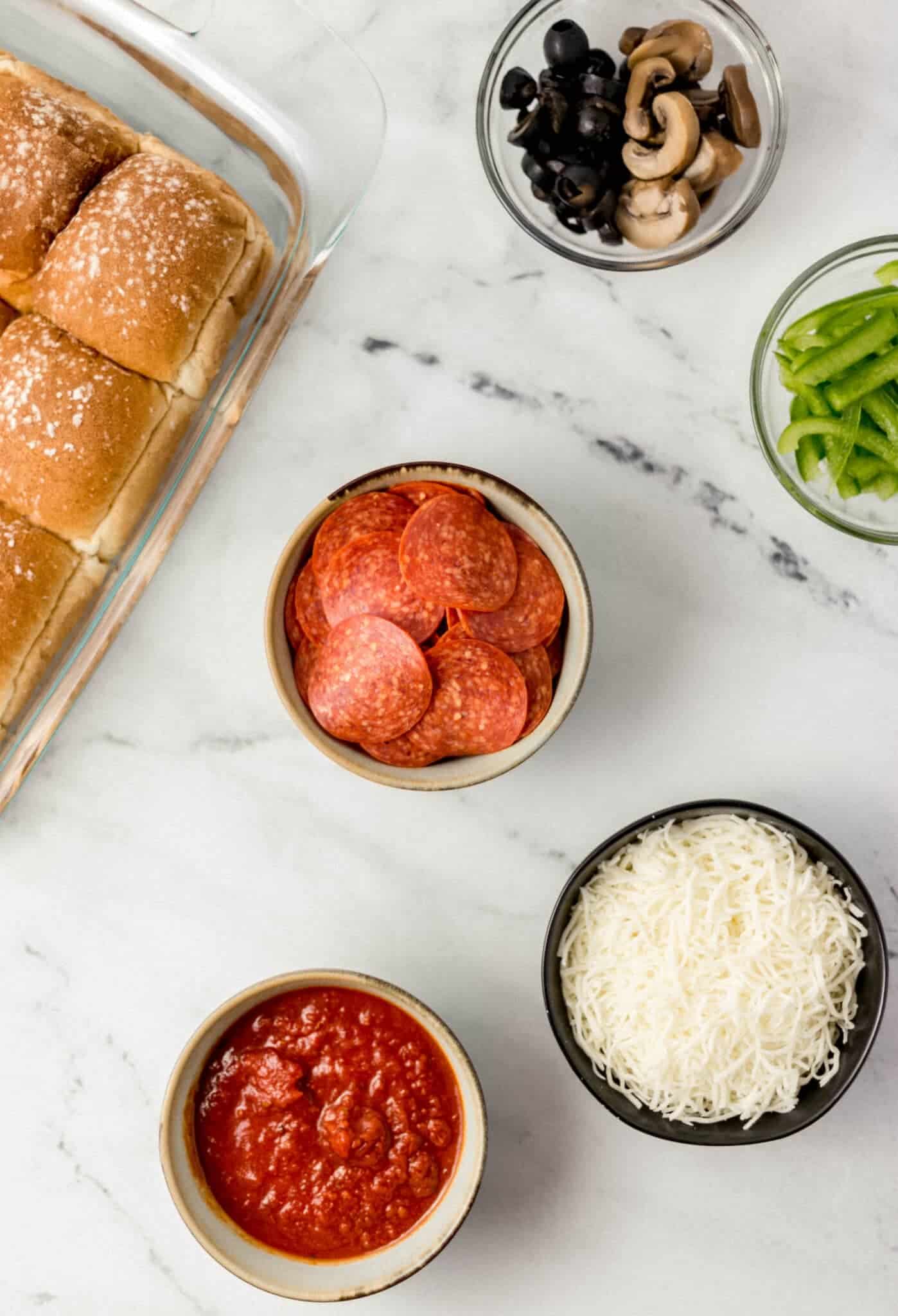 ingredients to make rolls in separate containers on marble surface 