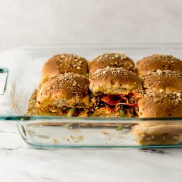 close up side view of finished pizza rolls in rectangle glass baking dish