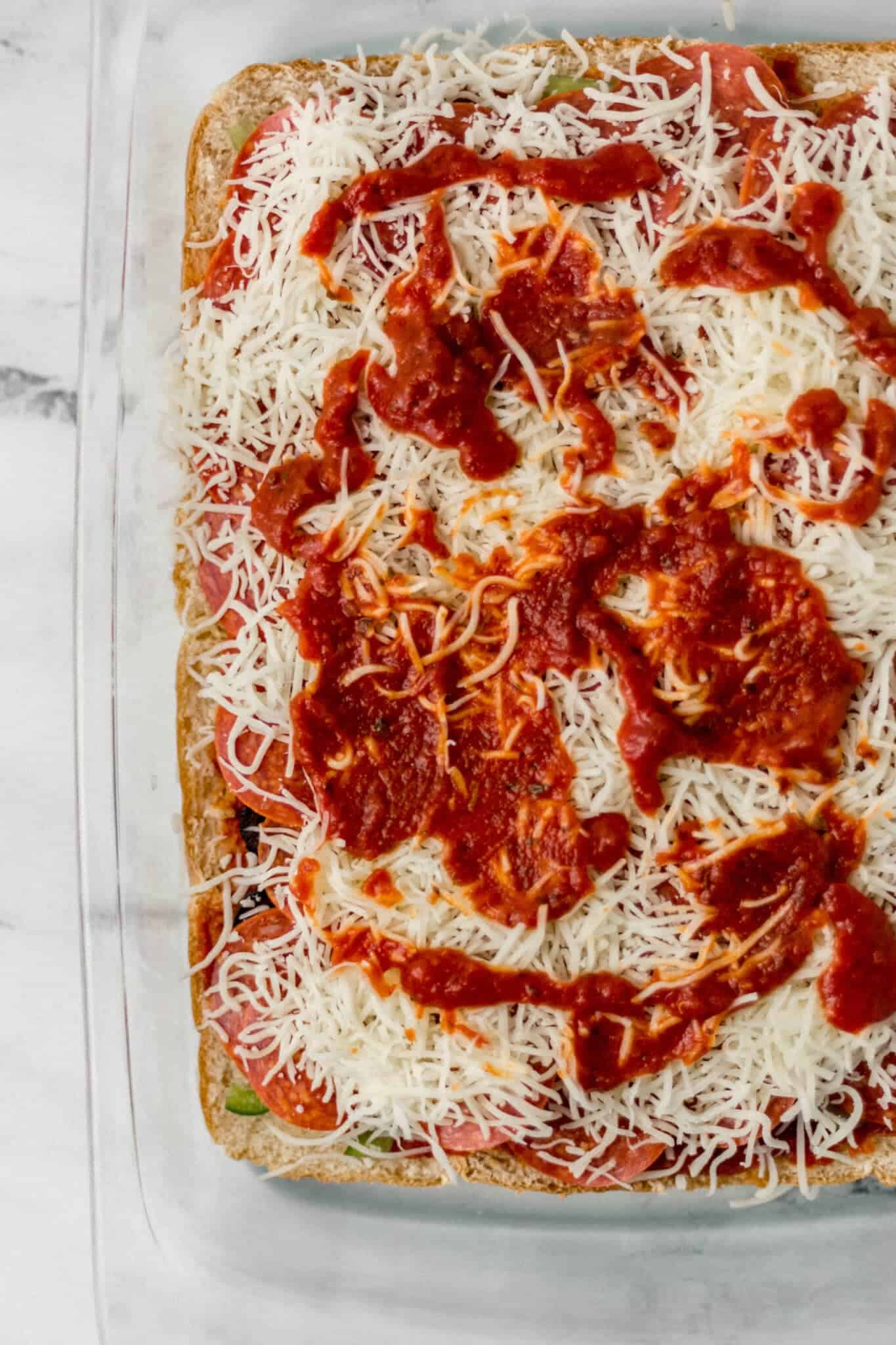 overhead view of toppings piled on top of bottom half of rolls