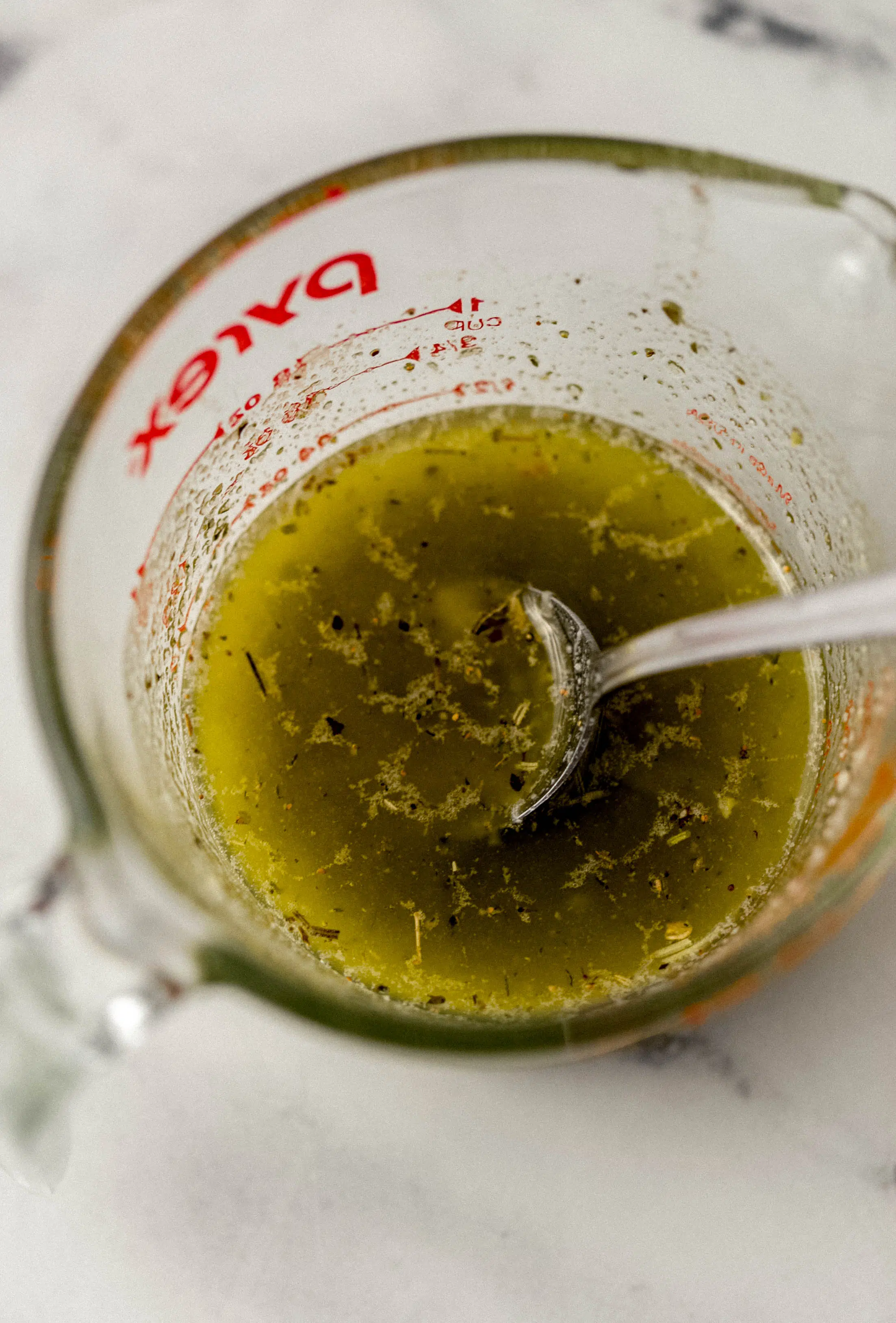 ingredients to make sauce combined in mixing cup with spoon