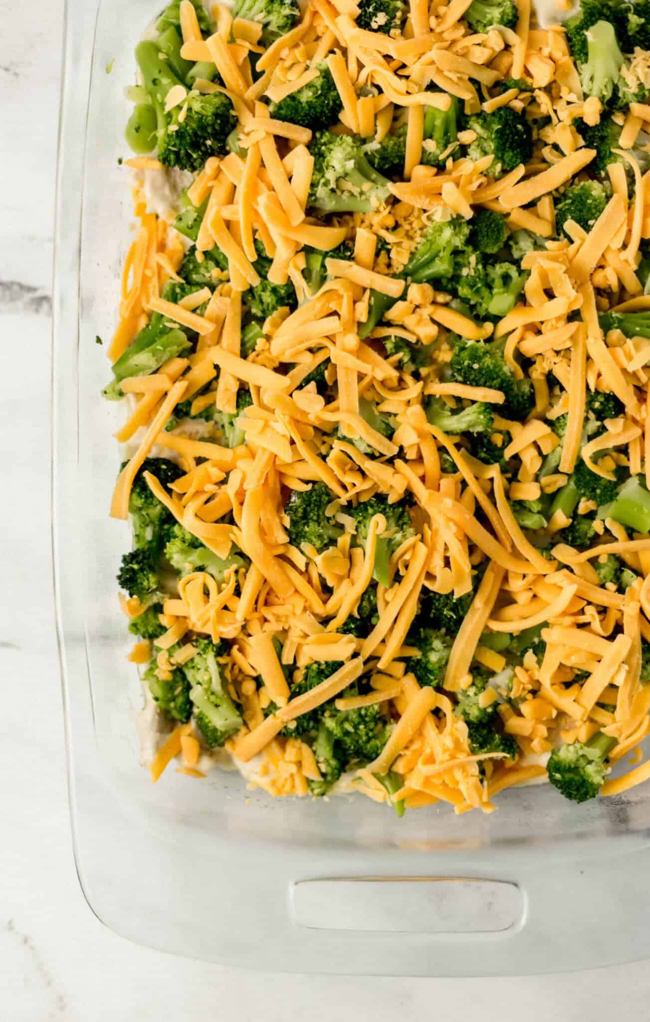 shredded cheese spread on top of unbaked casserole 