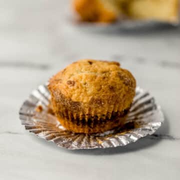 close up side view of muffin on top of liner with another muffin in the background