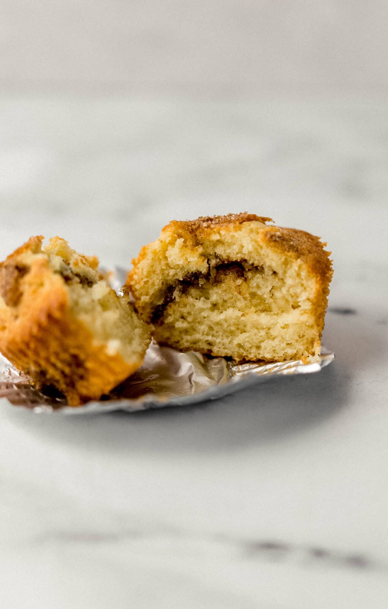 single muffin cut in half on silver liner
