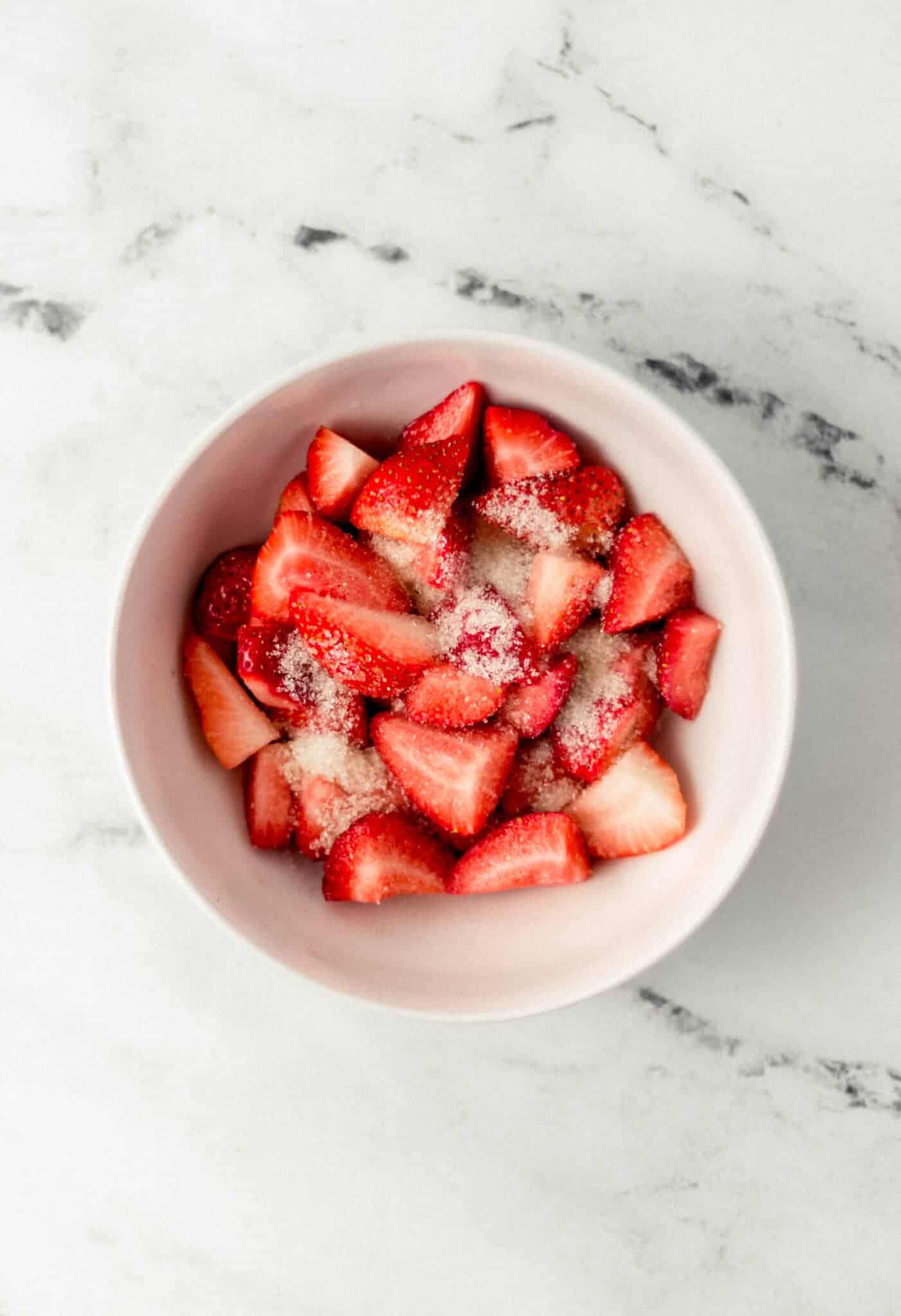 strawberries and sugar in a white bowl 
