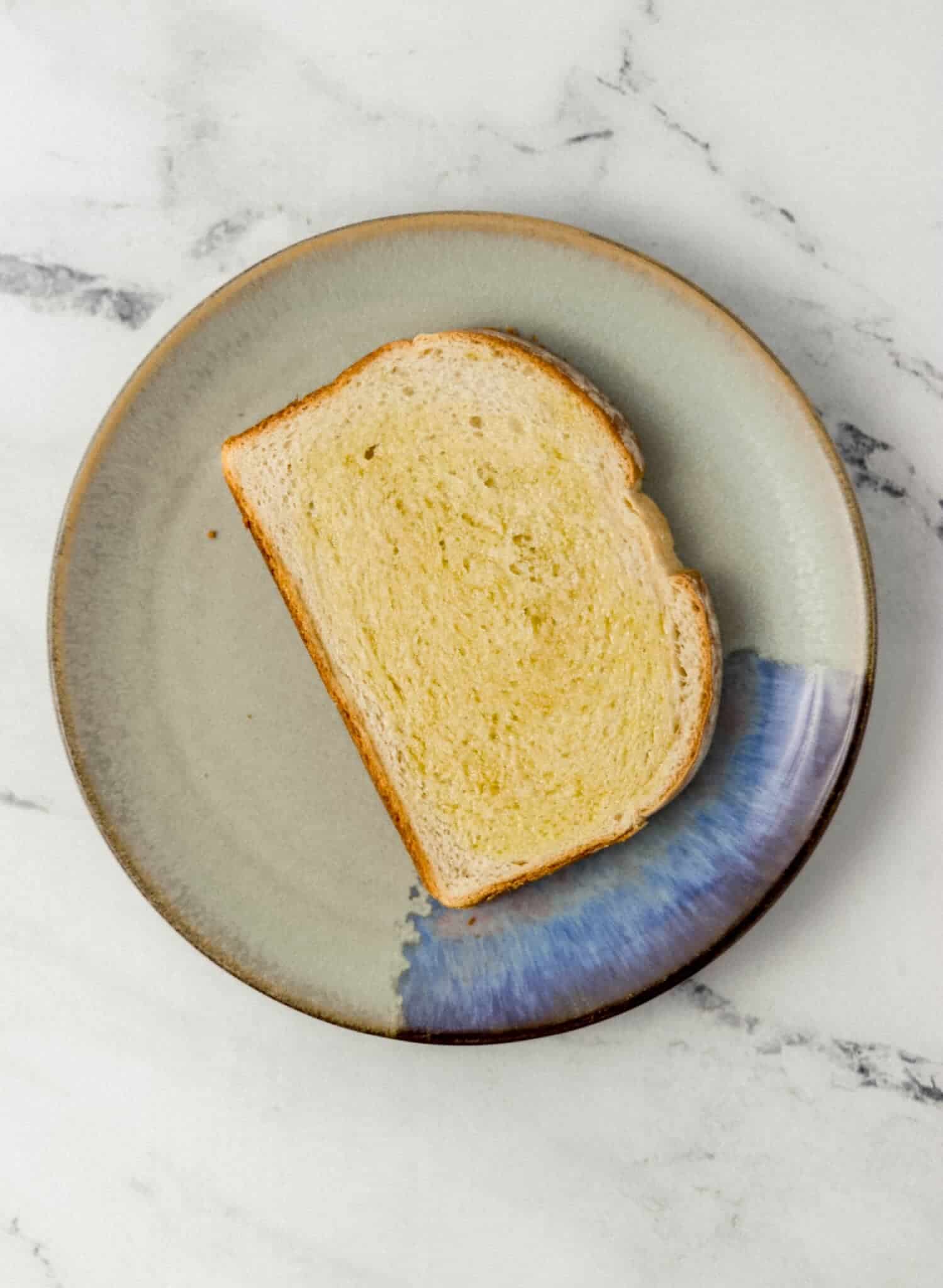 slice of bread topped with olive oil on a plate