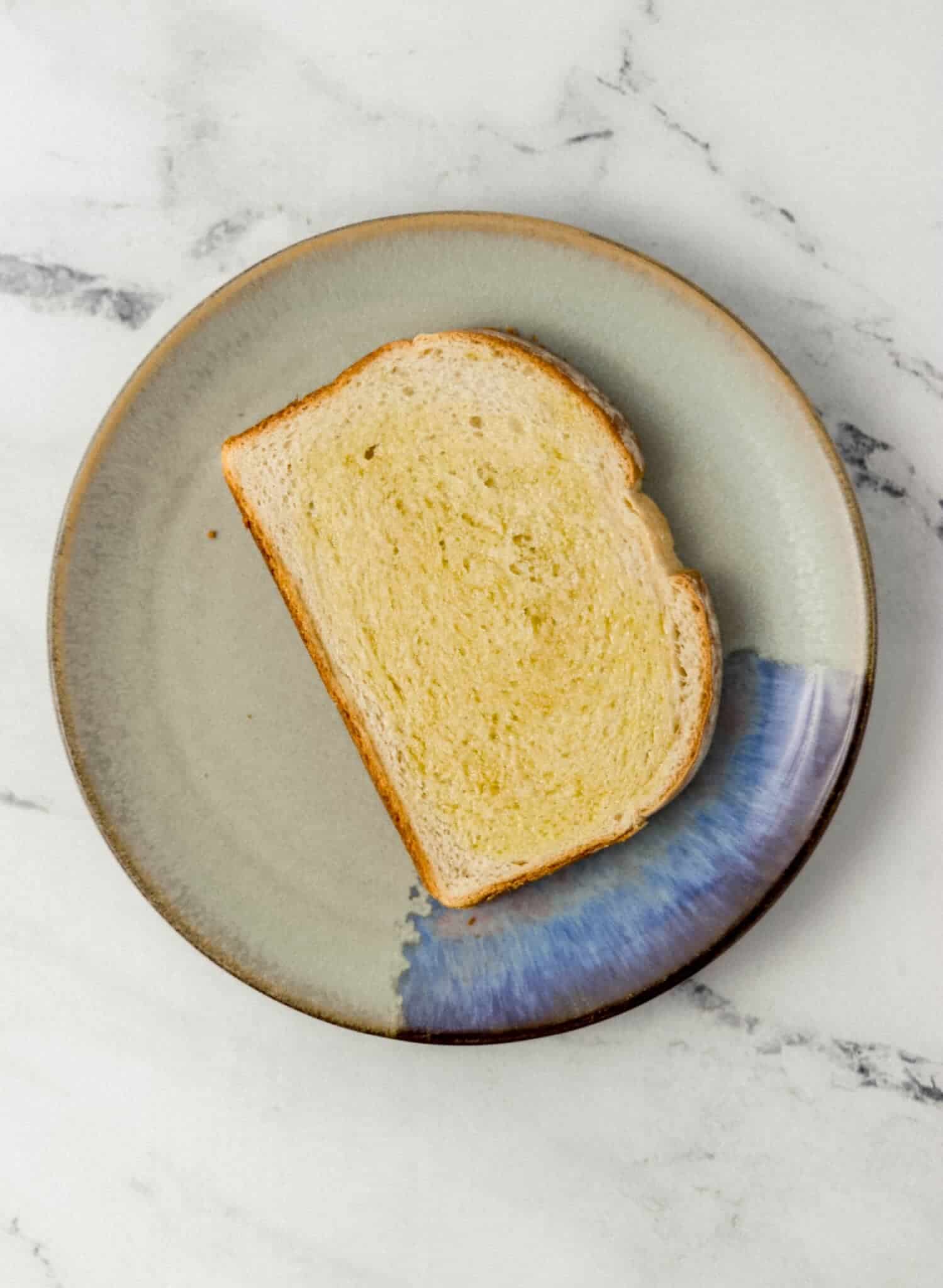 slice of bread topped with olive oil on a plate 