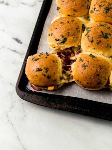 close up side view of finished sliders on sheet pan