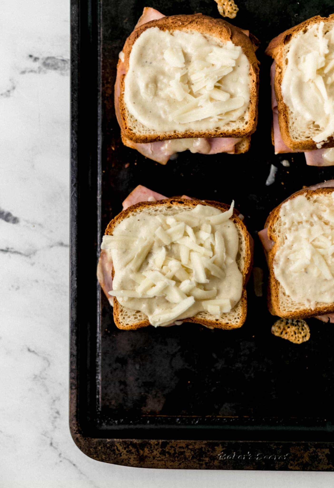 baked sandwiches topped with sauce and shredded cheese