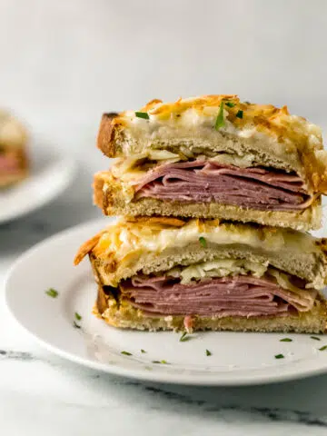 close up view of croque monsieur cut in half on white plate