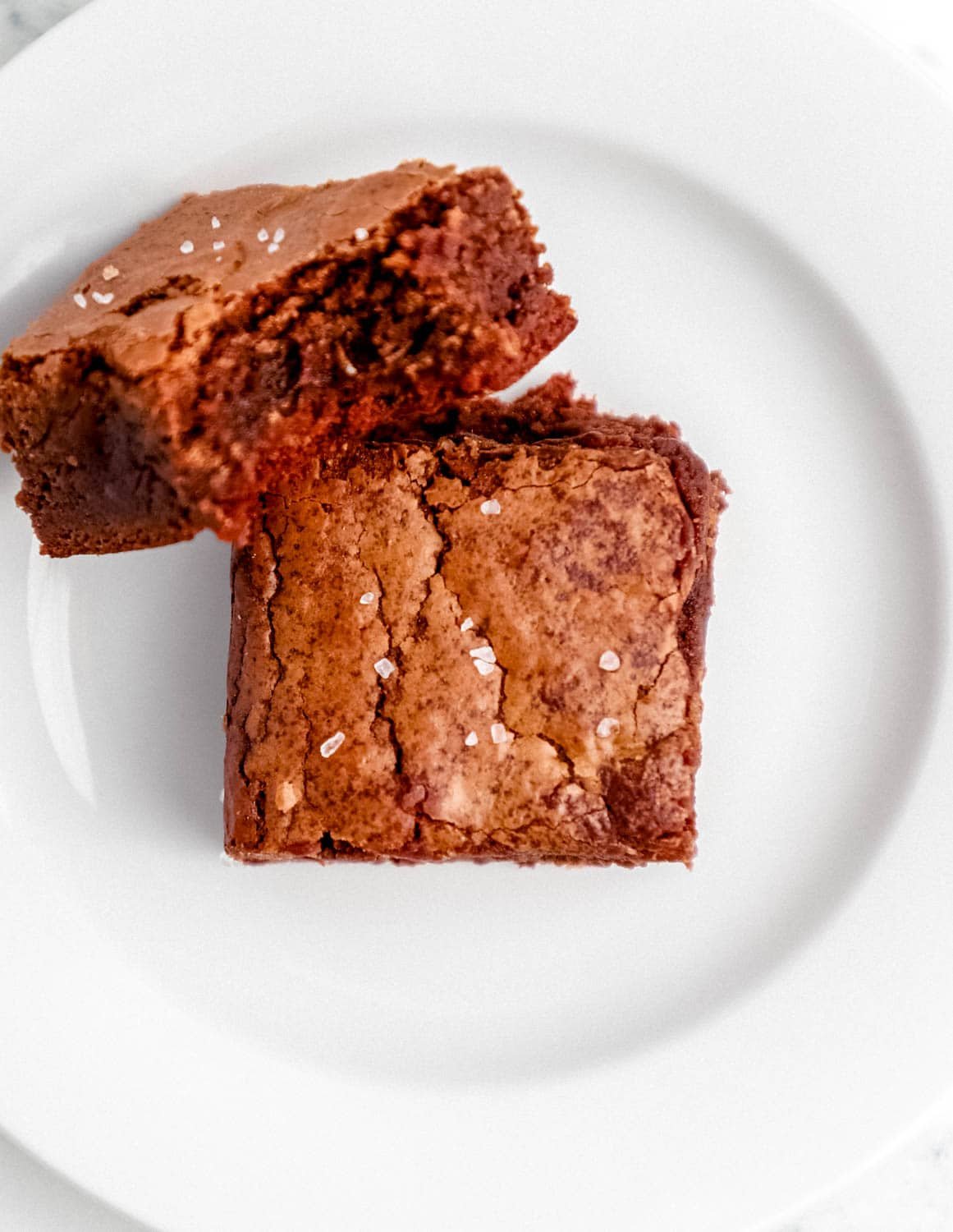 Two brownies on small white plate. 