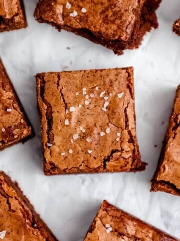 Finished brownies on parchment paper topped with salt.