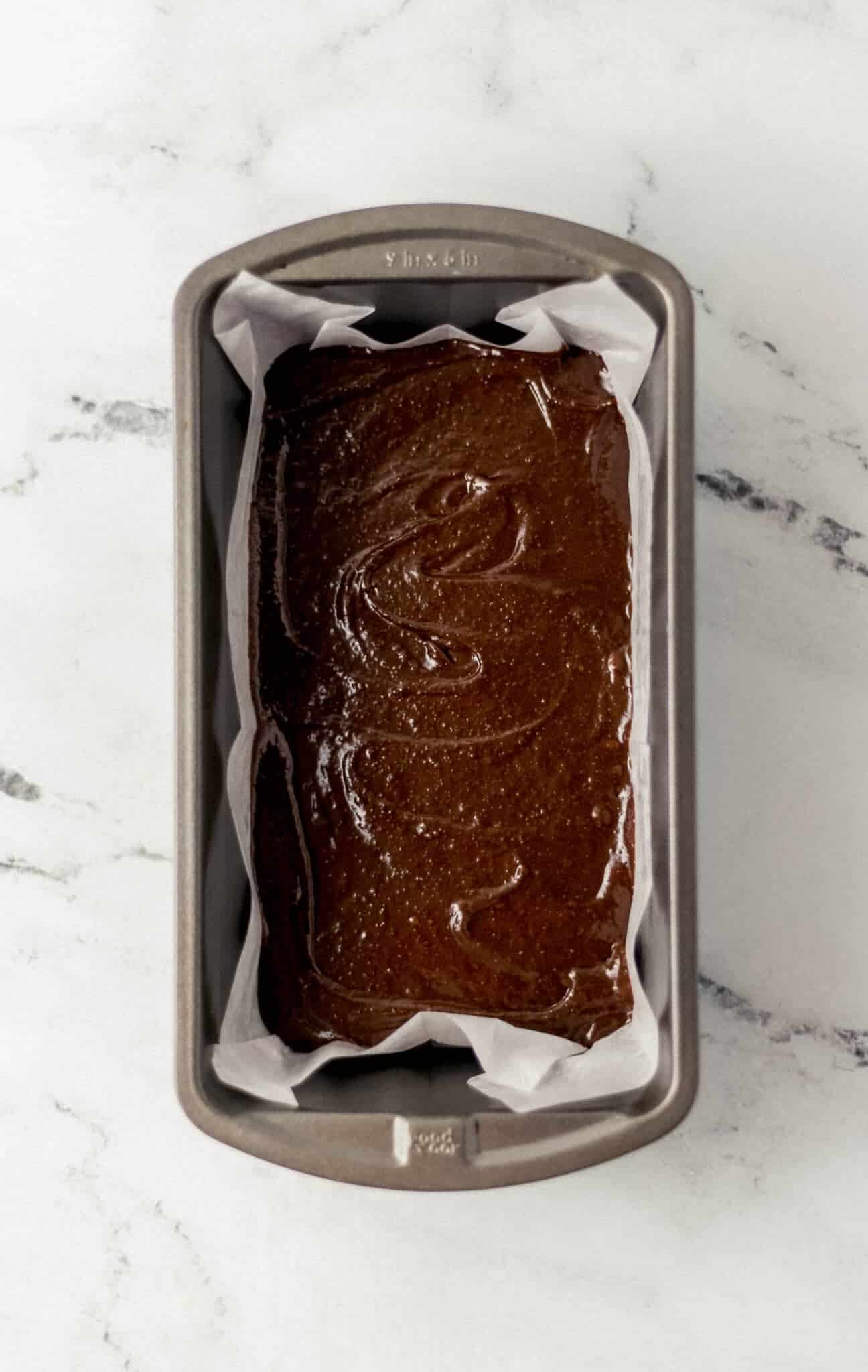 brownie mixture added to parchment lined loaf pan before baking