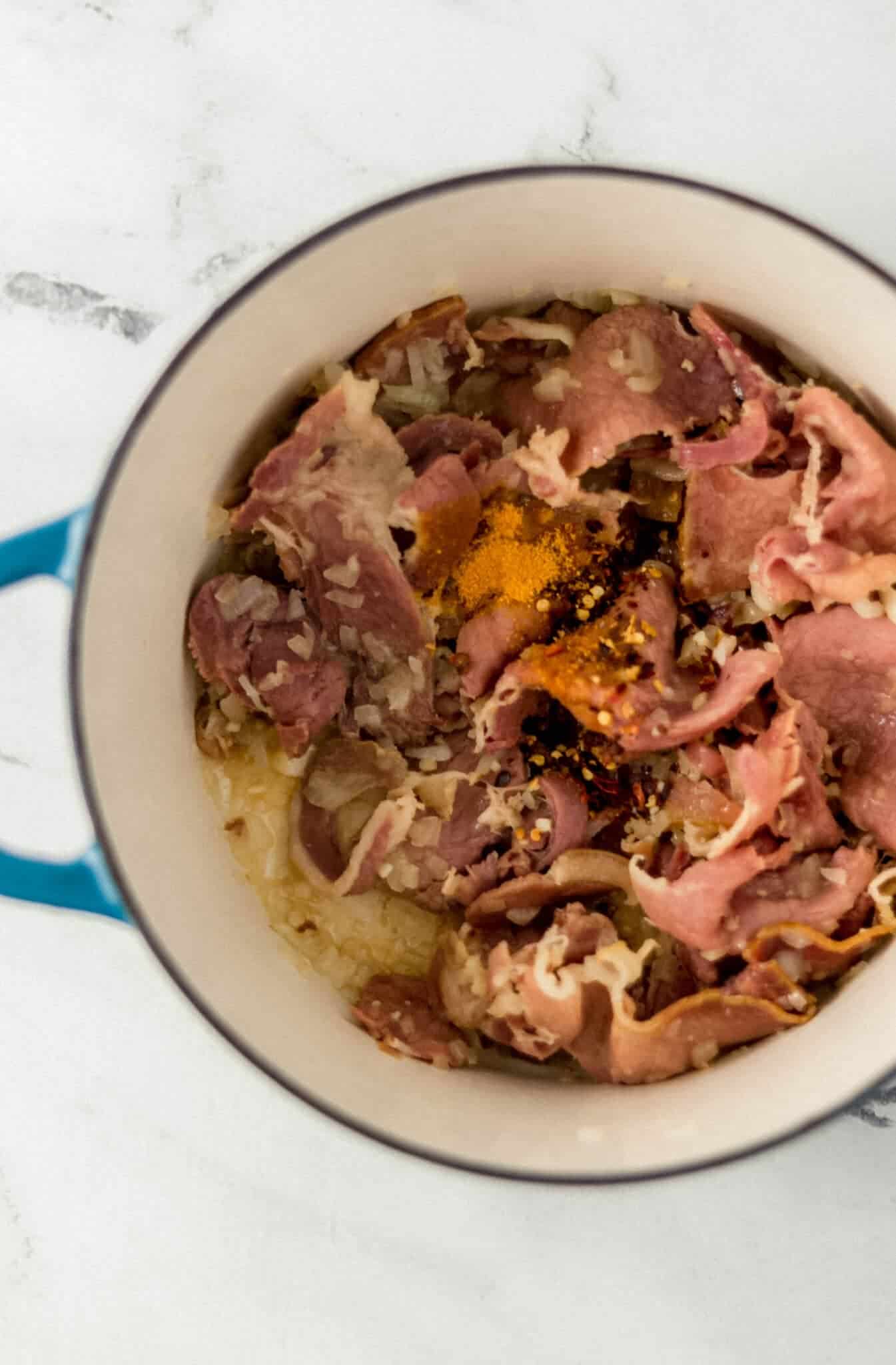 ham, onion, and seasoning added to large pot with oil 