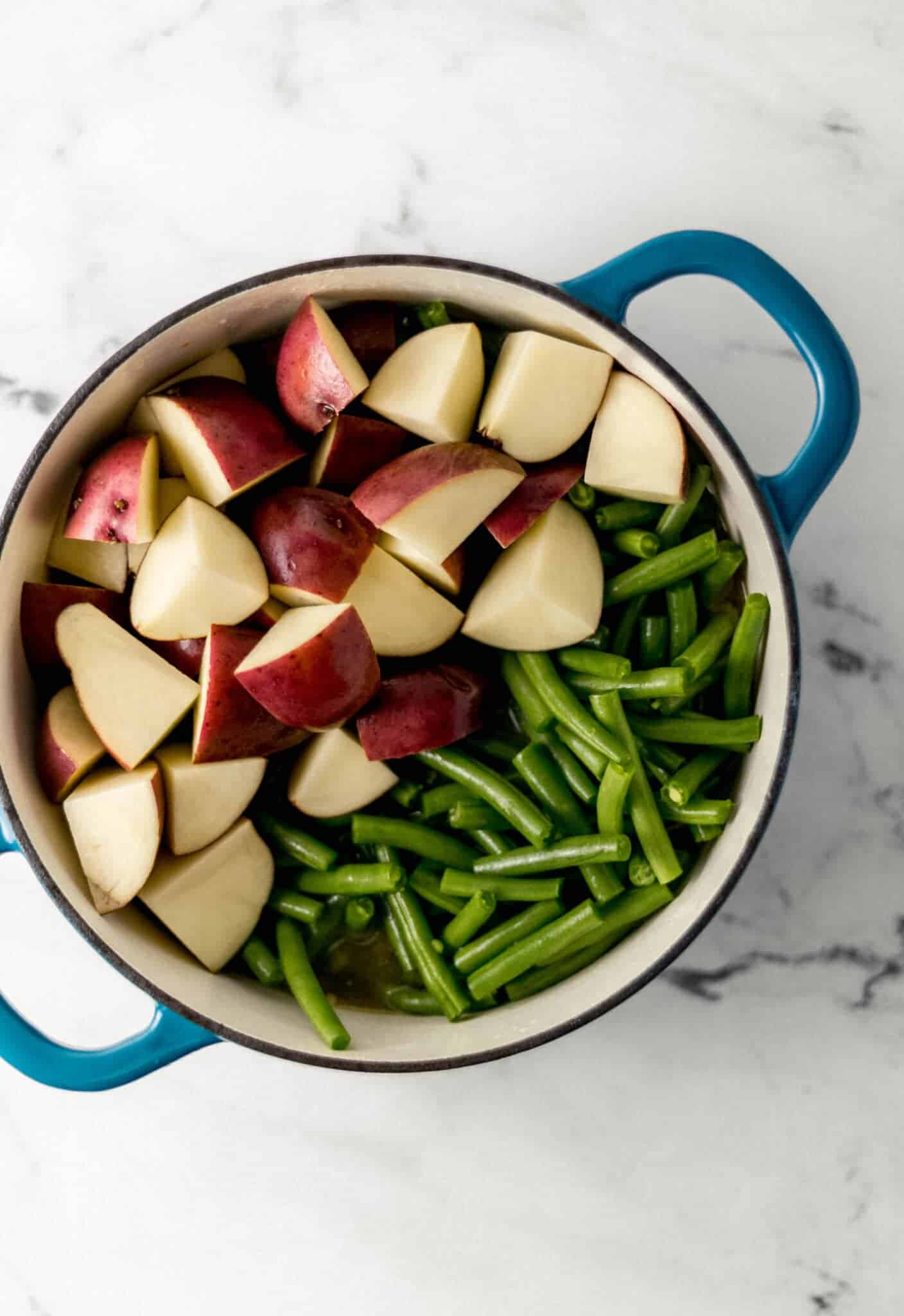 fresh green bean and quartered red potatoes added to large pot