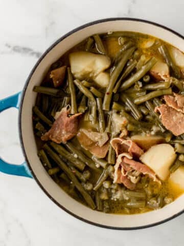 overhead view of finished ham, green beans, and potatoes in large pot