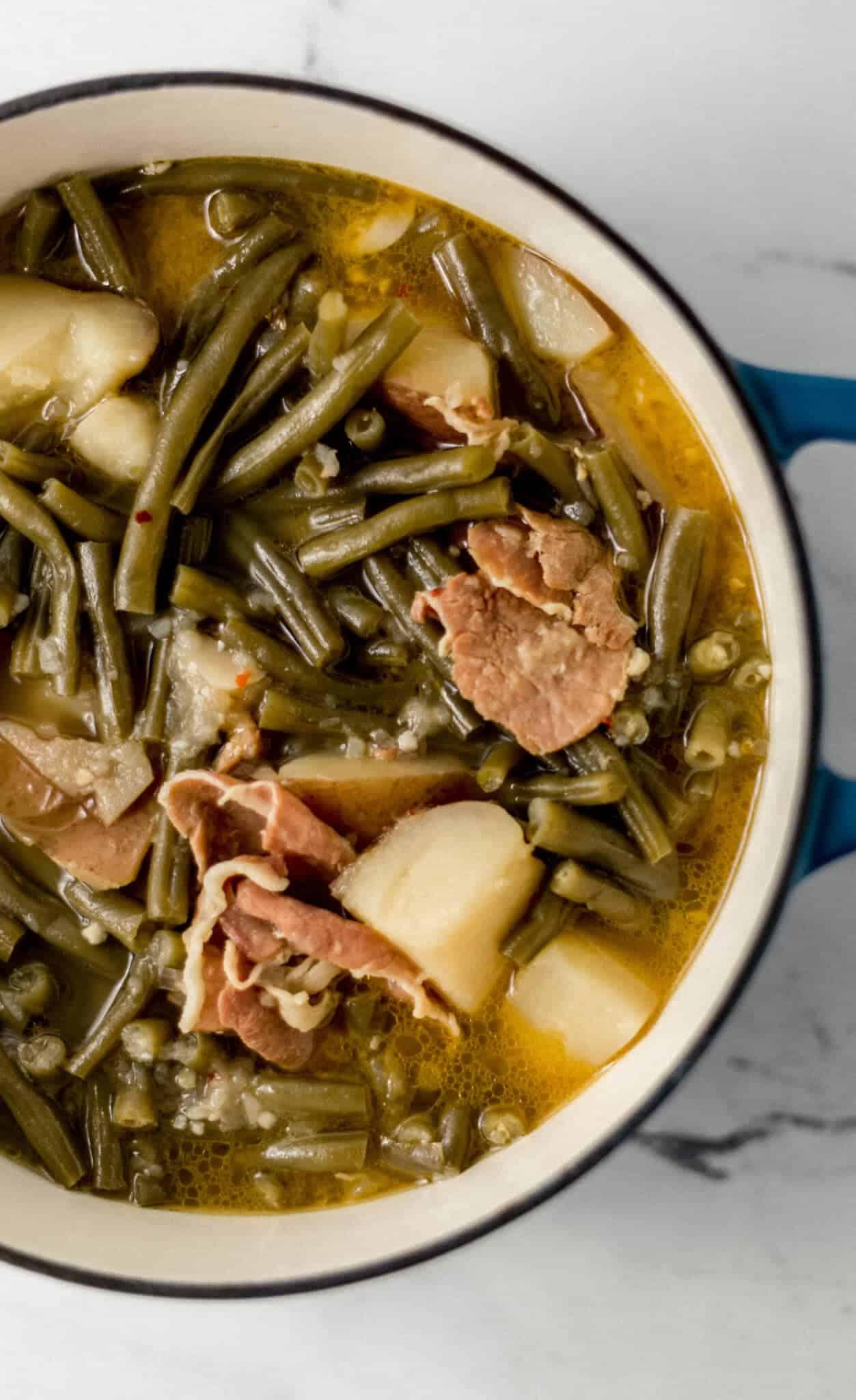 finished green beans in pot on marble surface 