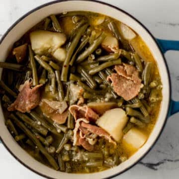 overhead view of green beans in large pot on marble surface