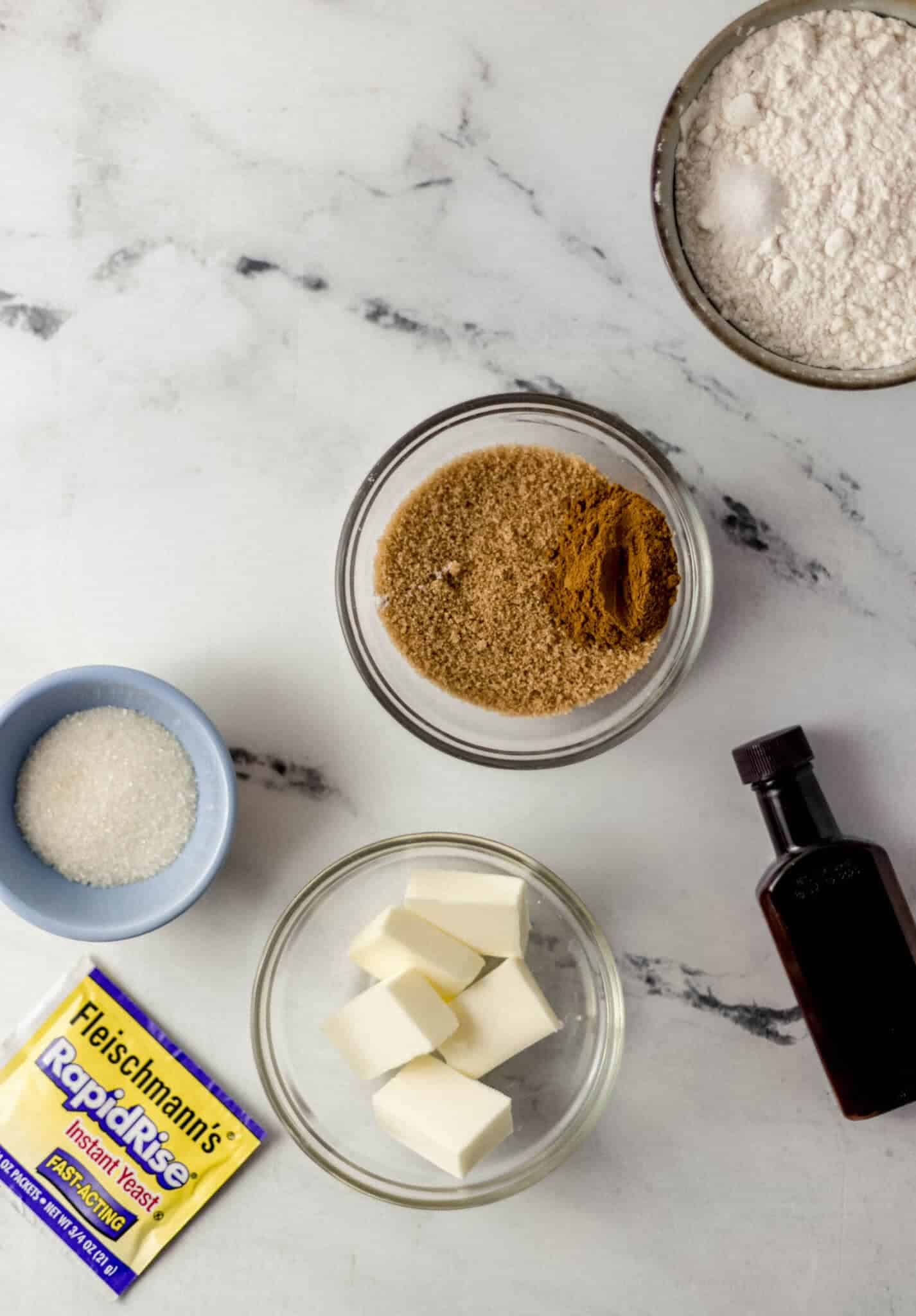 overhead view of ingredients needed to make cinnamon rolls in separate containers 