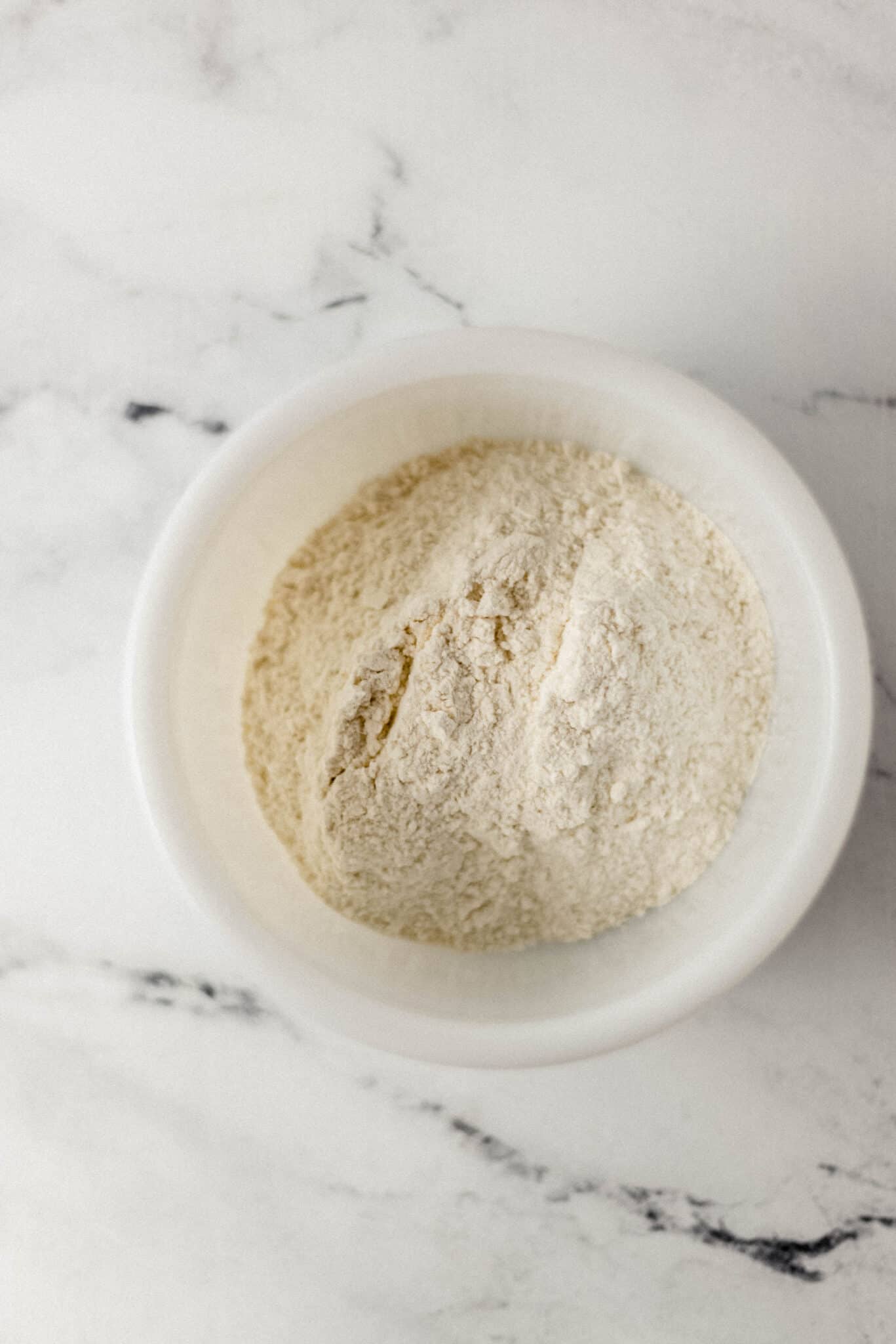 flour, salt, and sugar combined in white mixing bowl