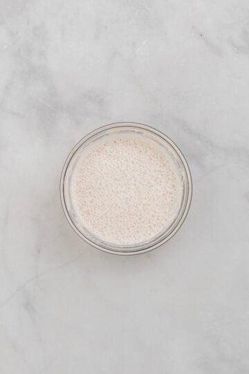 Yeast and warm milk combined in small glass bowl.