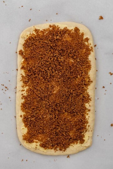 Dough rolled out and topped with butter, cinnamon, and sugar.