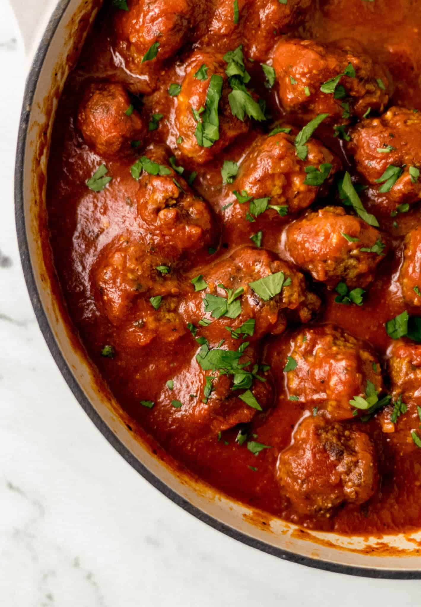 finished meatballs and sauce in pan covered with parsley 