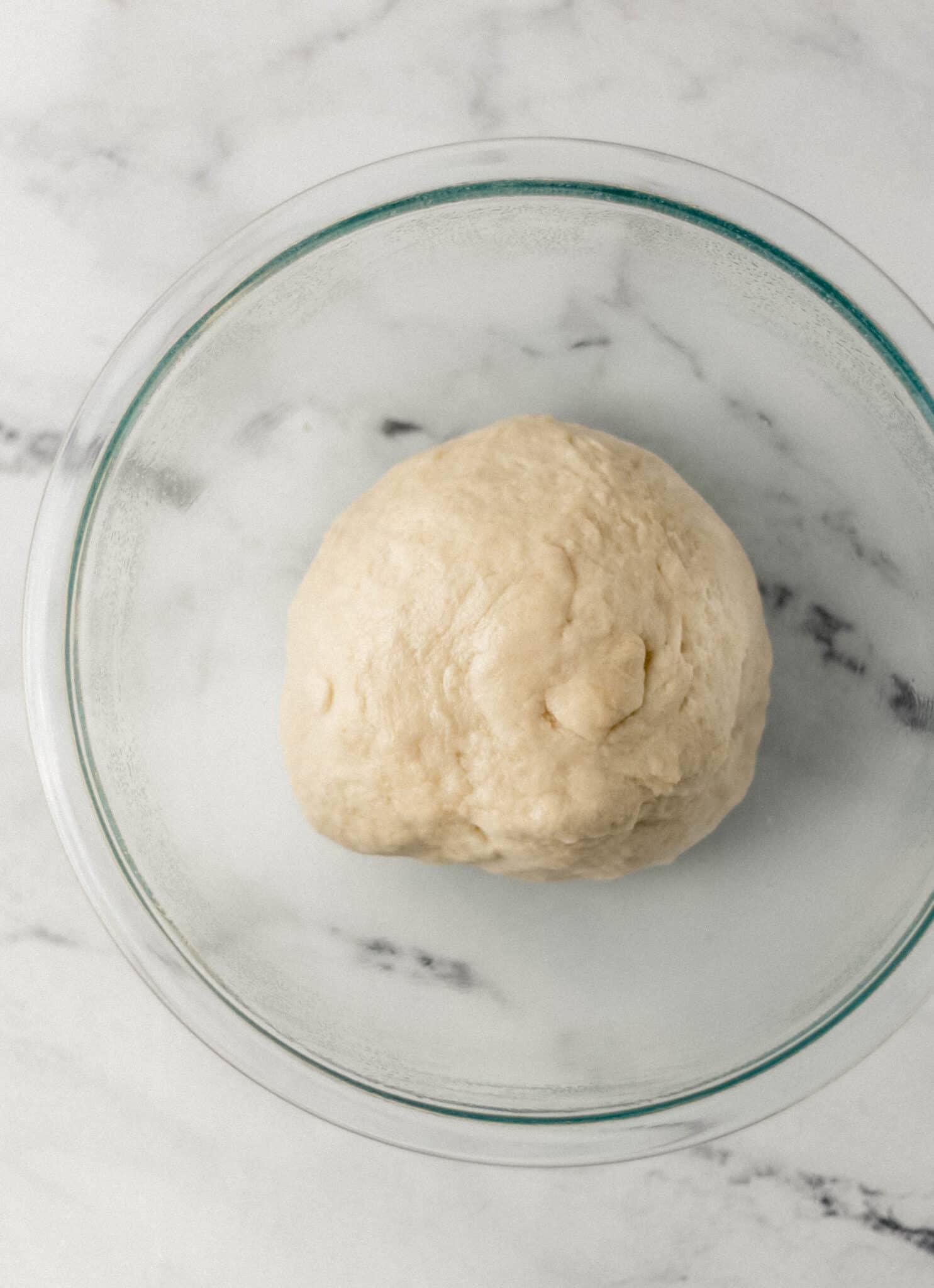 soft dough ball in glass mixing bowl