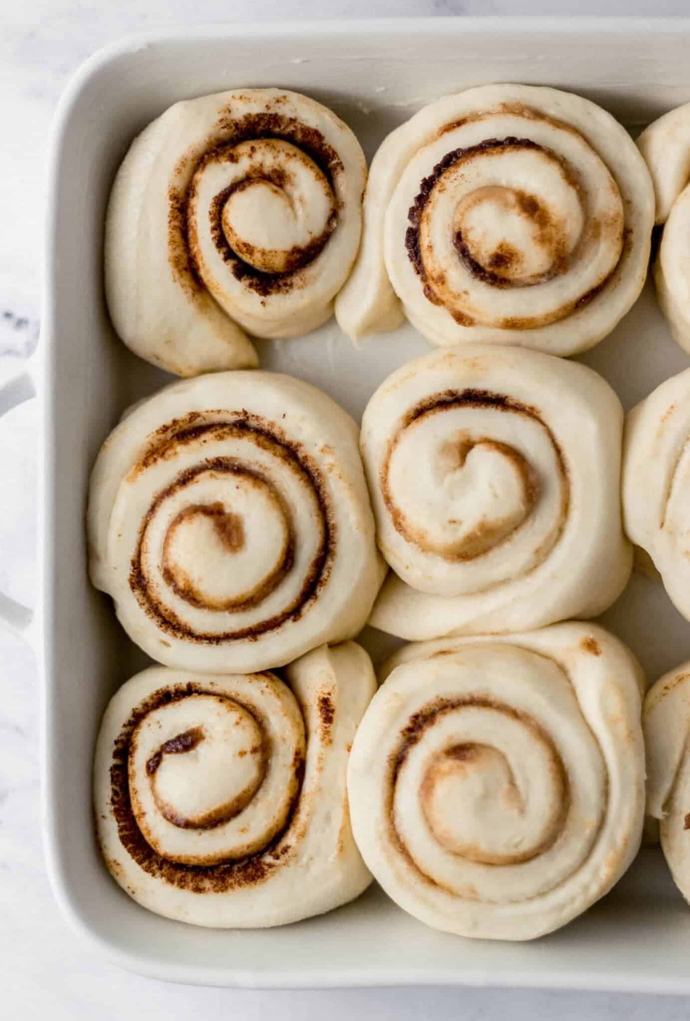 rolls that have rested for an hour before baking in prepared dish