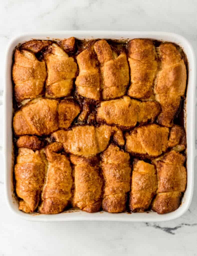 overhead view of finished apple dumplings in large square white baking dish 