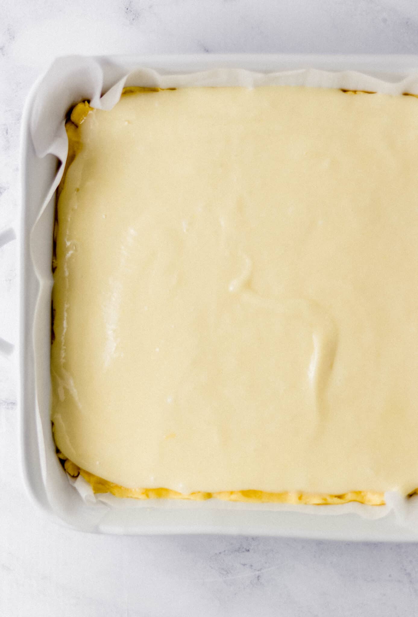 filling added on top of crust in parchment lined baking dish 