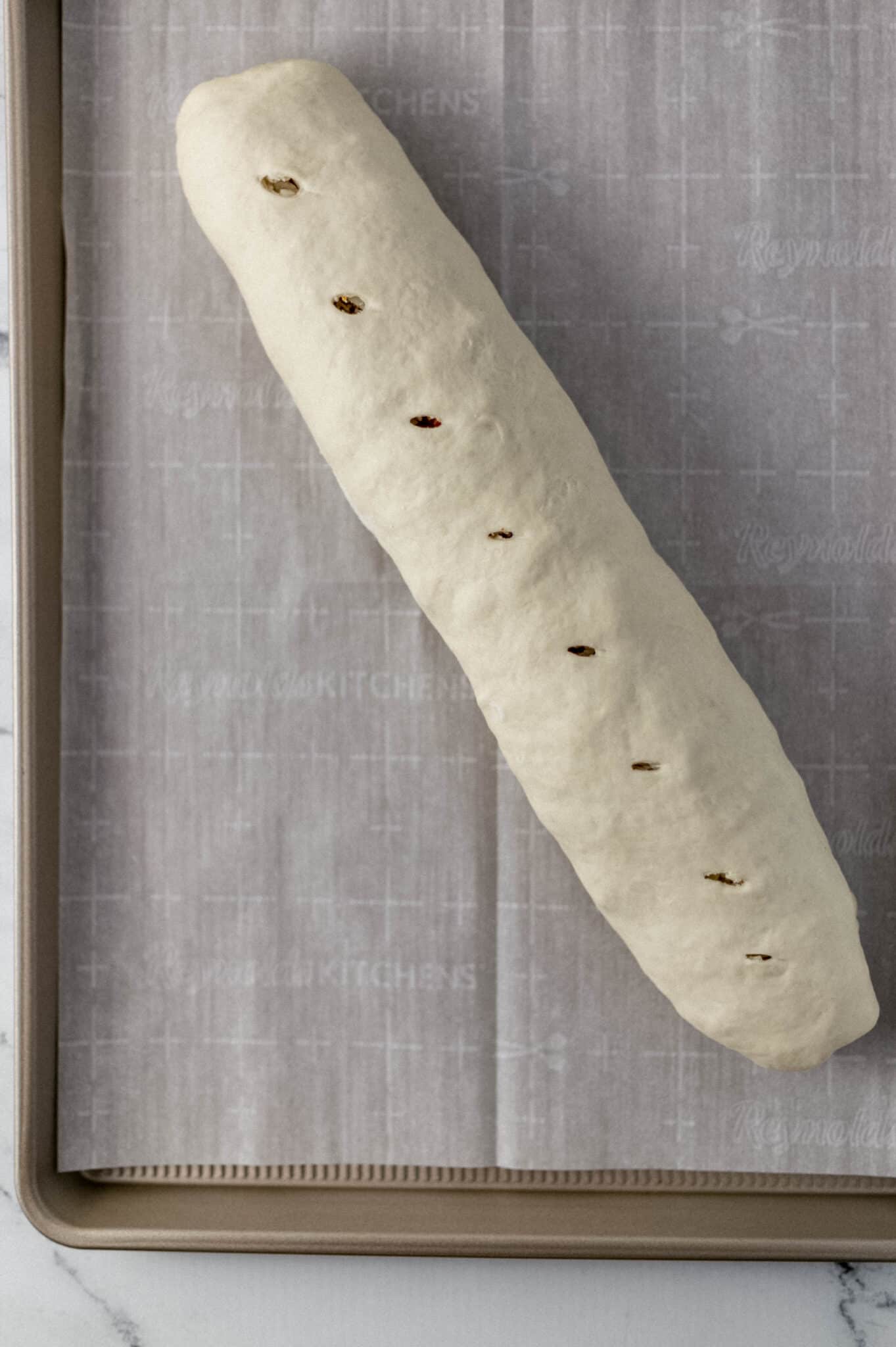 rolled bread on parchment lined baking sheet before baking