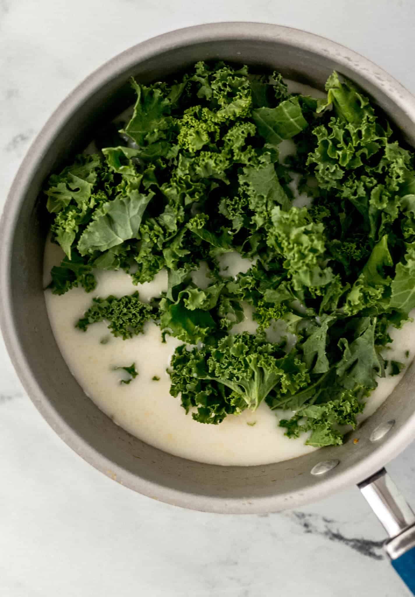 kale, potato, broth, and cream added to a saucepan 