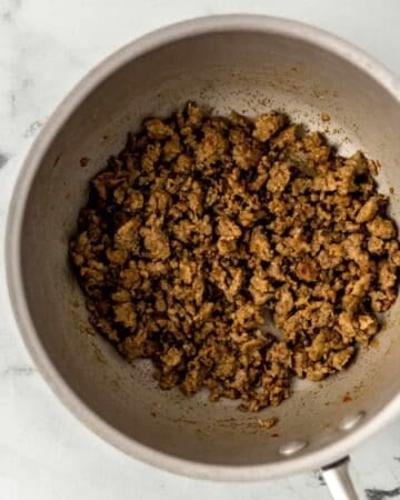 Overhead view of cooked sausage in saucepan.