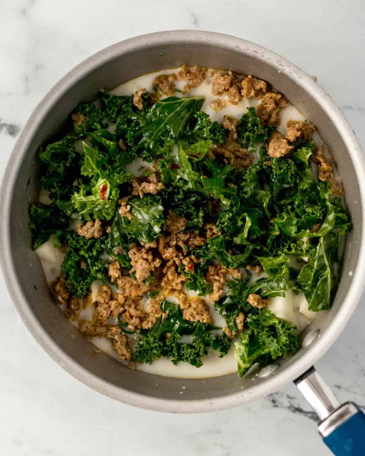 Potato Kale and Sausage Soup Simply LaKita 4 Sausage added to saucepan with other soup ingredients.