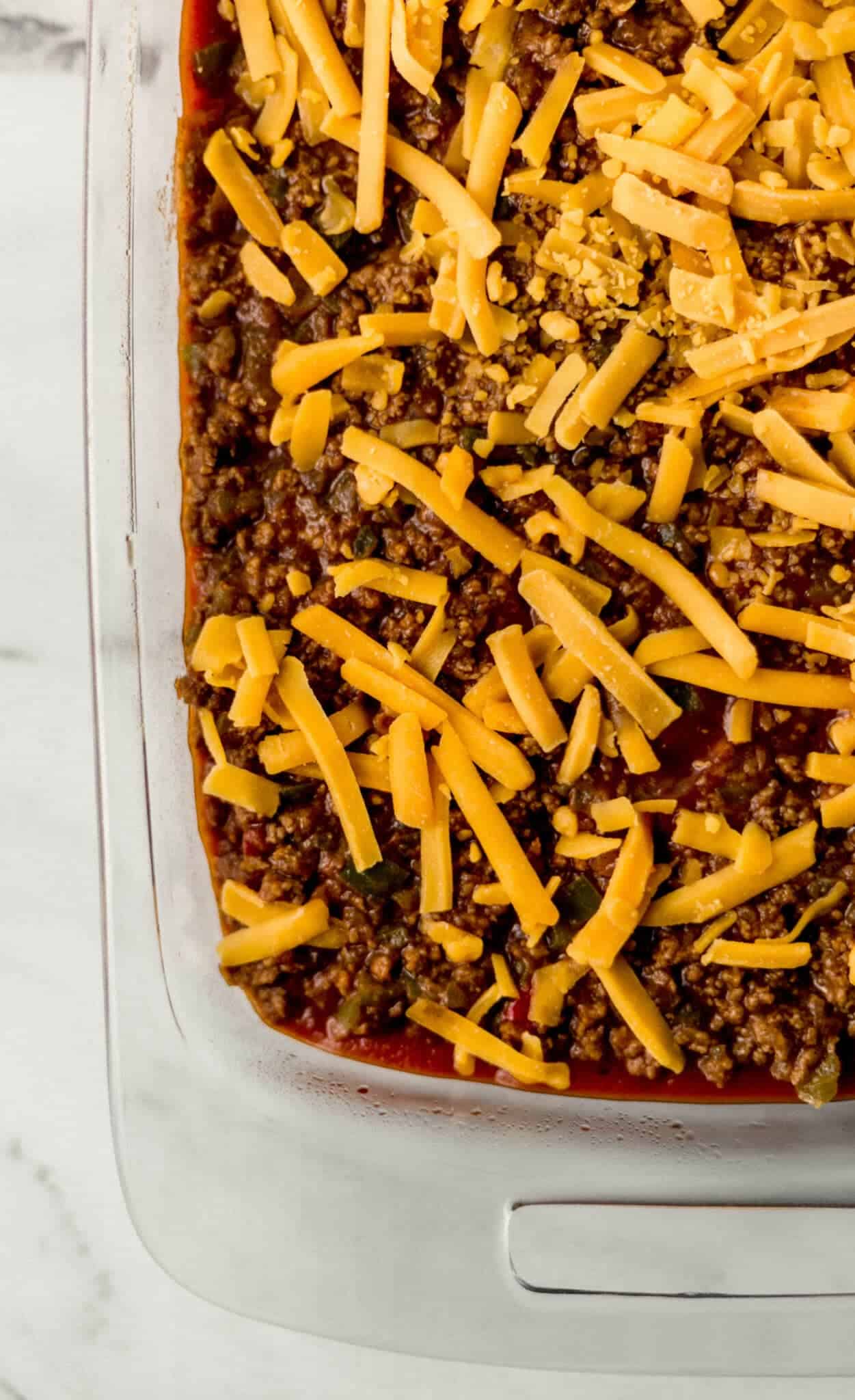 unbaked assembled cornbread casserole in glass baking dish 