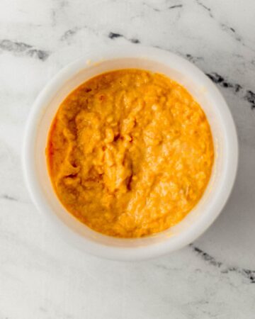 Overhead view of wet ingredients combined in white mixing bowl.
