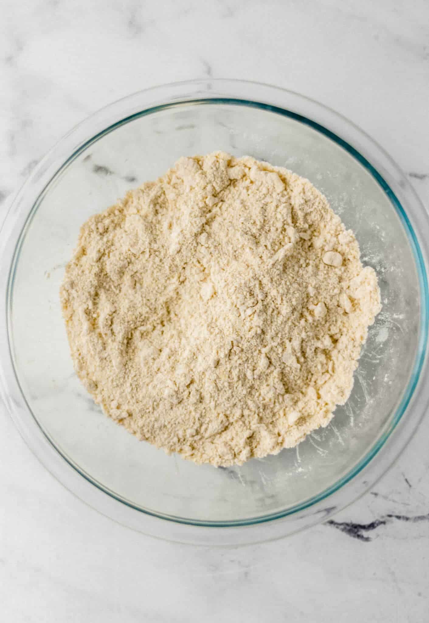 dry ingredients combined with butter in large glass mixing bowl