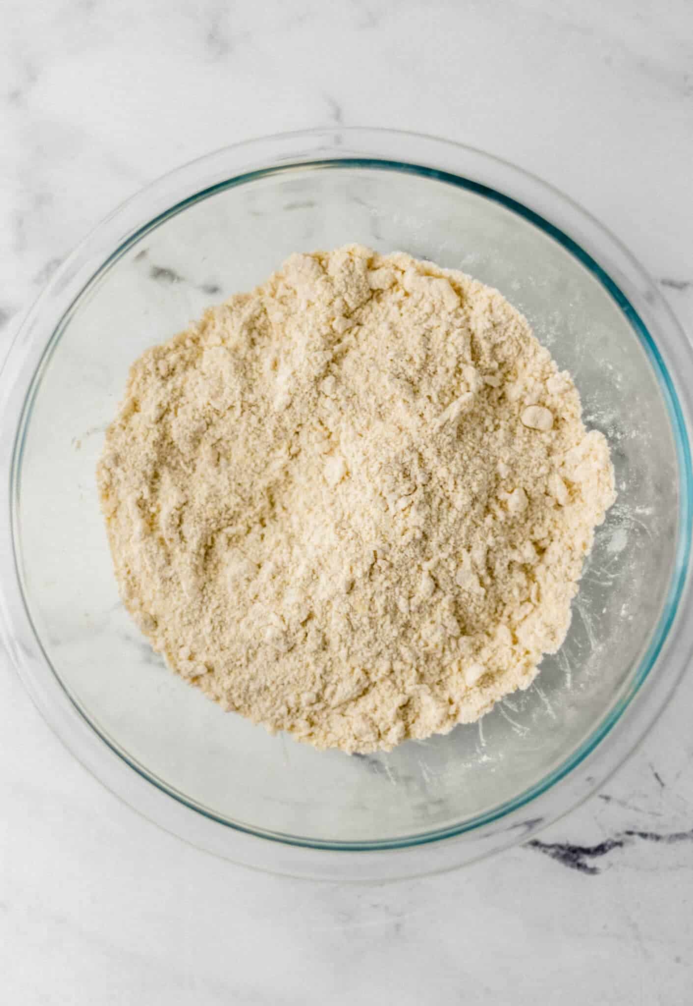 dry ingredients combined with butter in large glass mixing bowl 