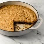 cookie in skillet with a piece cut out of it