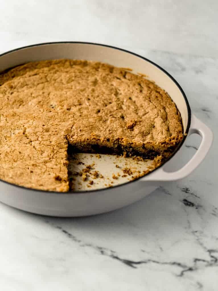cookie in skillet with a piece cut out of it