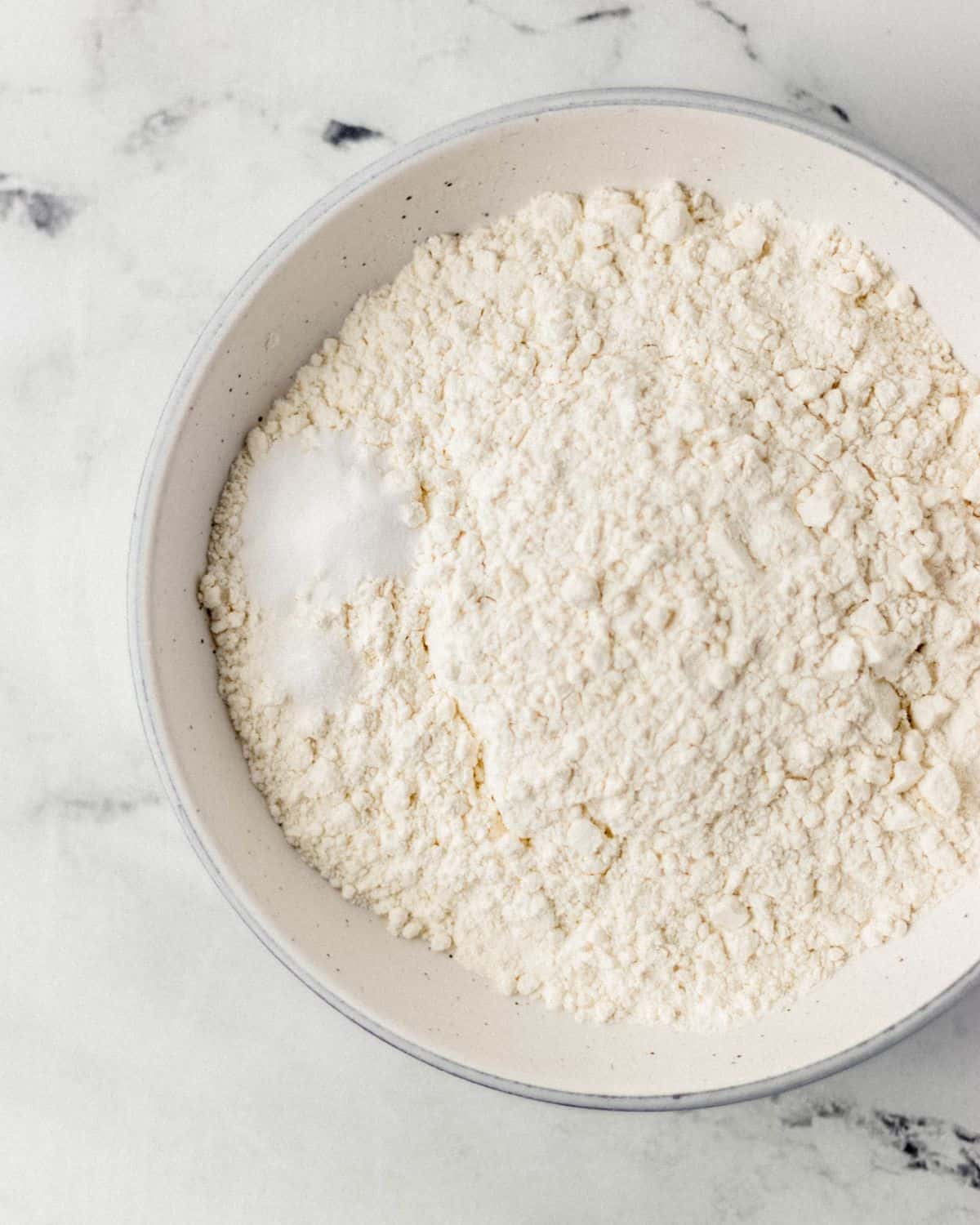 Overhead view of bowl of dry cookie ingredients.