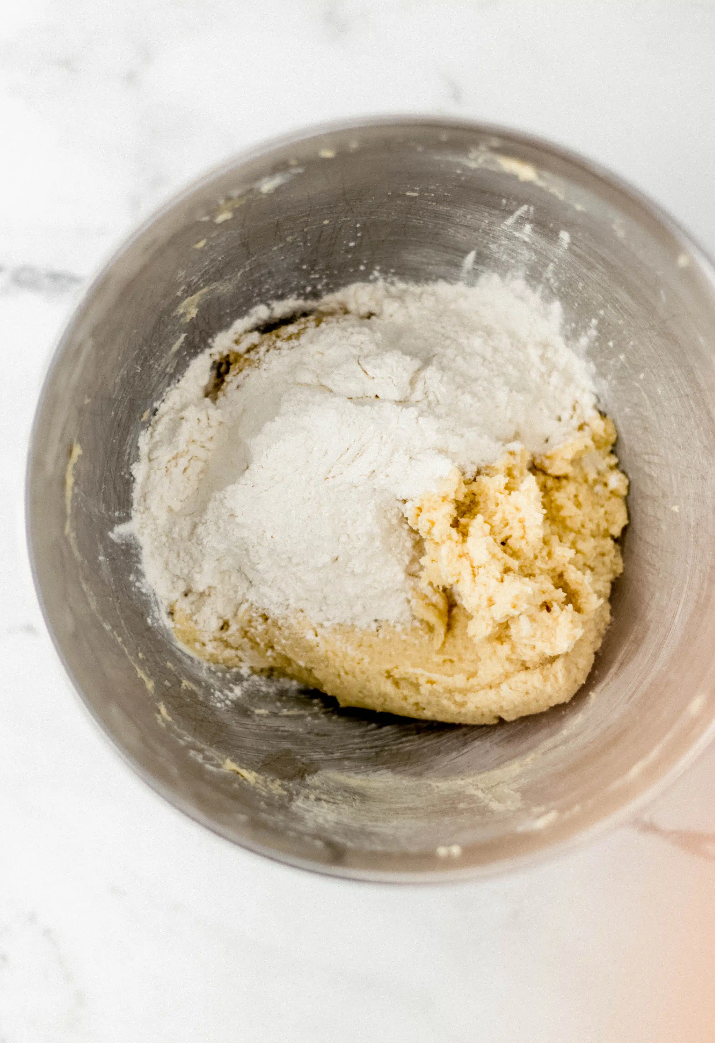 flour mixture added to cookie mixture in mixing bowl 