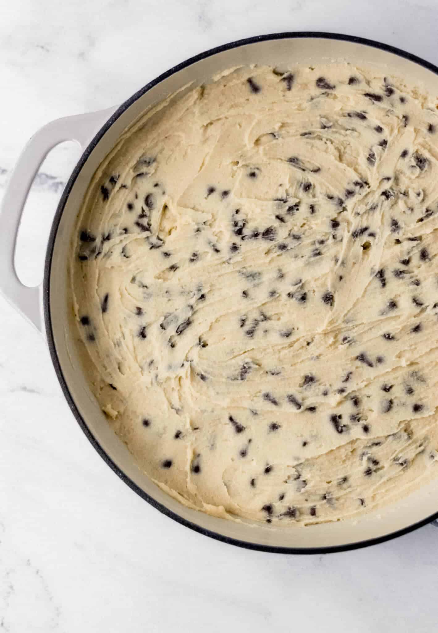 Chocolate Chip Cookie Skillet Recipe cookie dough spread in large cast iron skillet
