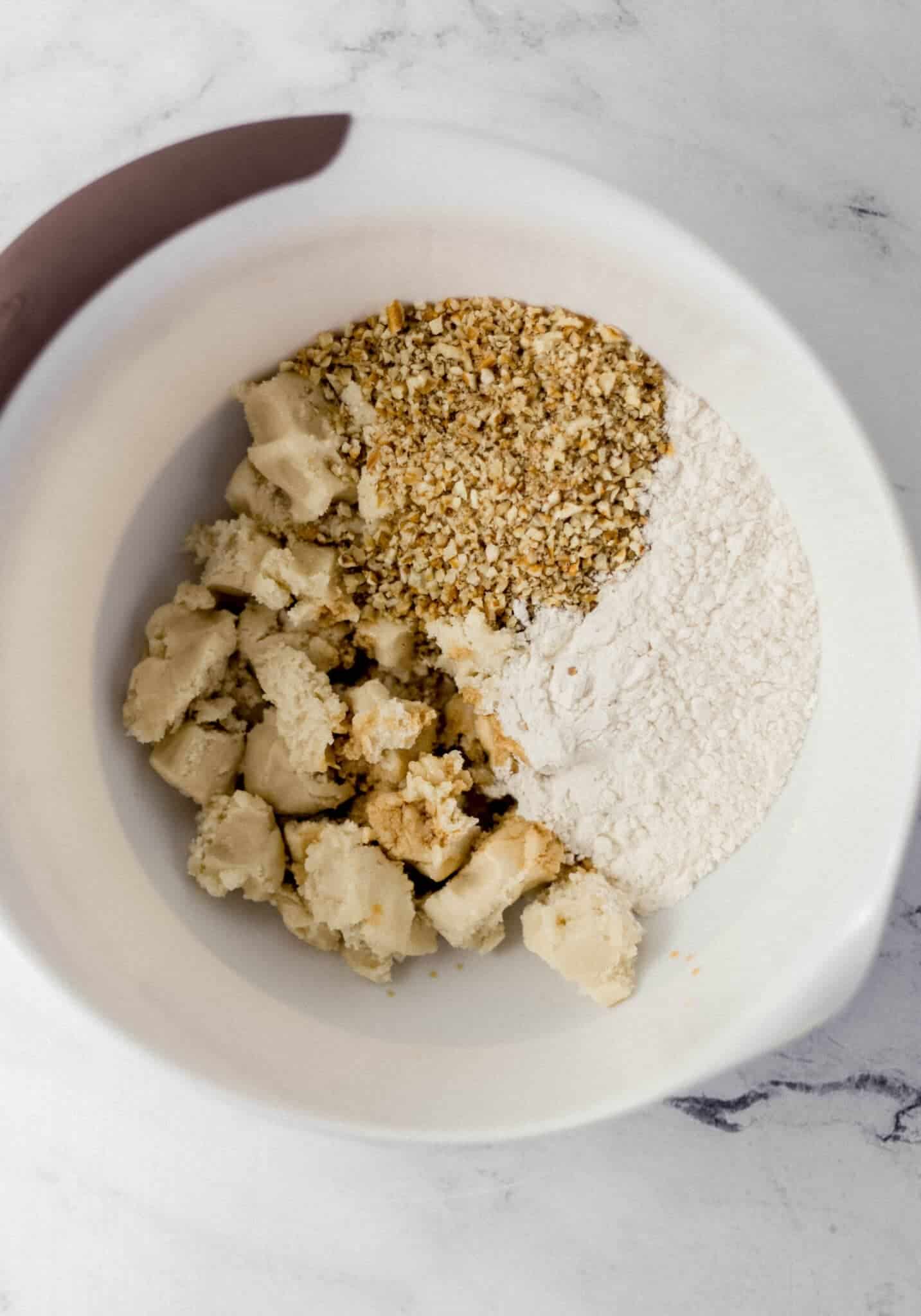 cookie dough, pecans, flour, and vanilla in a mixing bowl 