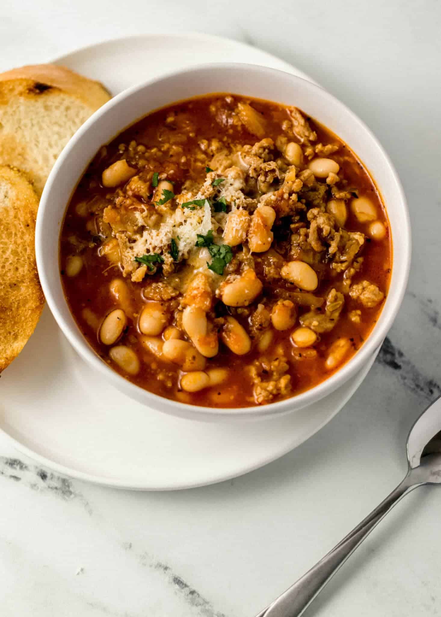 close up view of bowl of soup on plate with bread