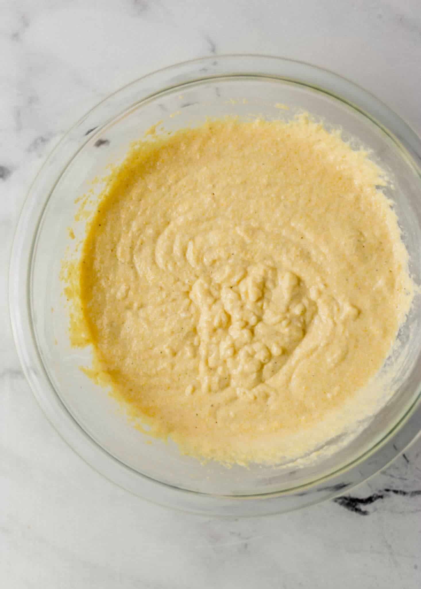cornbread ingredients mixed together in glass mixing bowl 