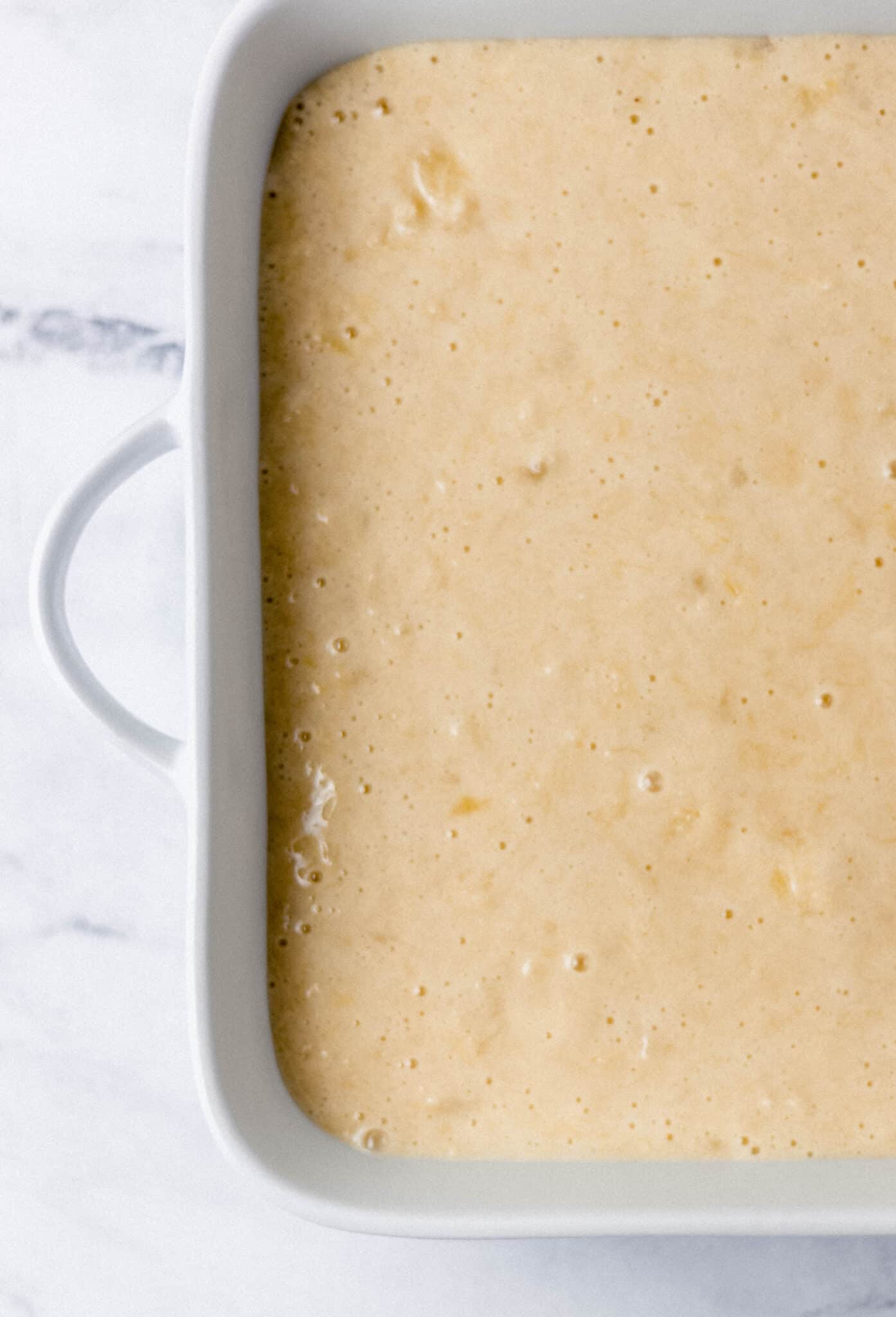 cake mix added to white baking dish 