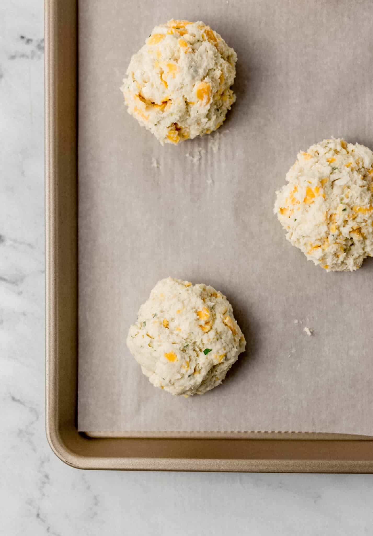 unbaked biscuits on parchment lined baking sheet